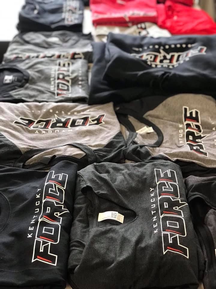 A bunch of shirts are stacked on top of each other on a table.