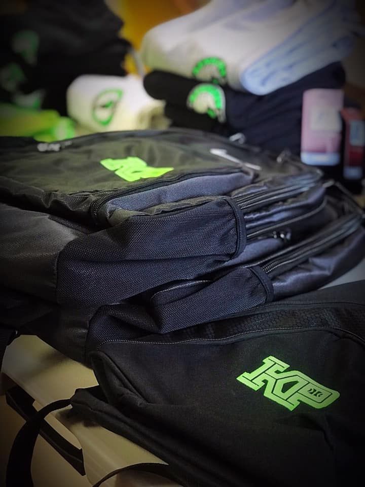 A black bag with a green kp logo on it