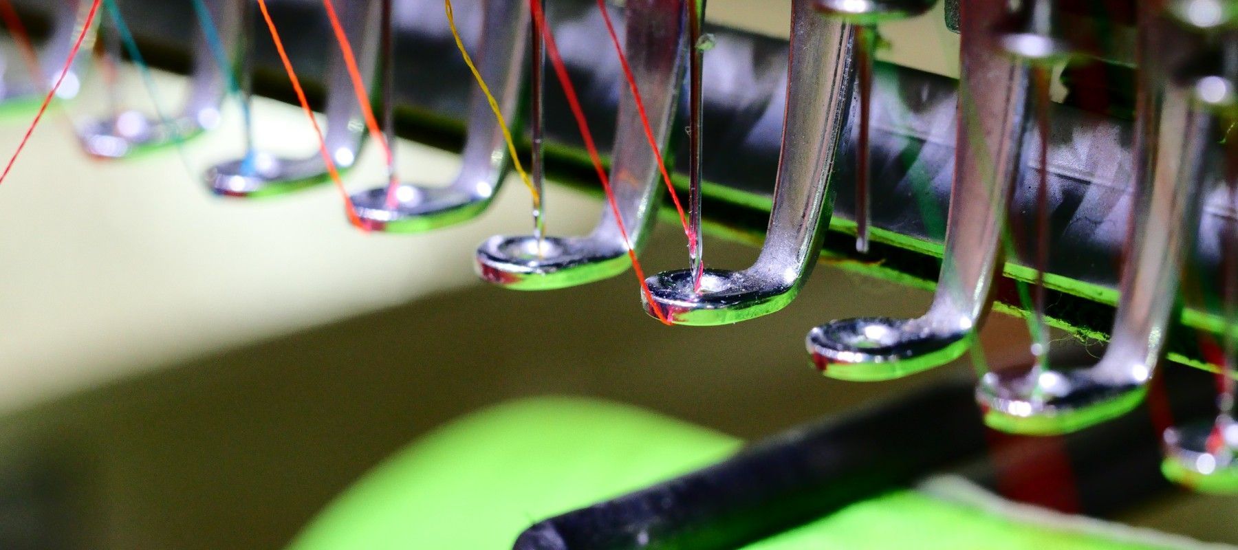 A close up of a sewing machine with a lot of needles.