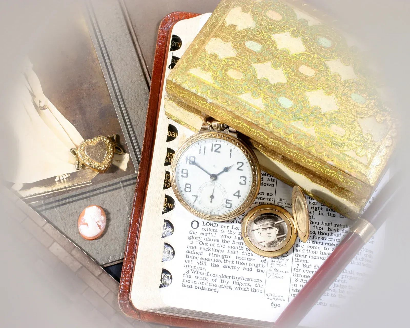 Antique items: pocket watch, jewelry box, notebook, pen, and cameo.