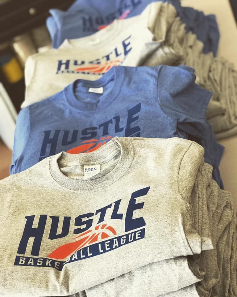 A stack of hustle basketball all league t-shirts