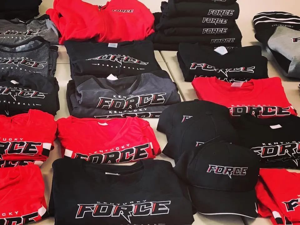 Folded red, black, and gray shirts and hats with 