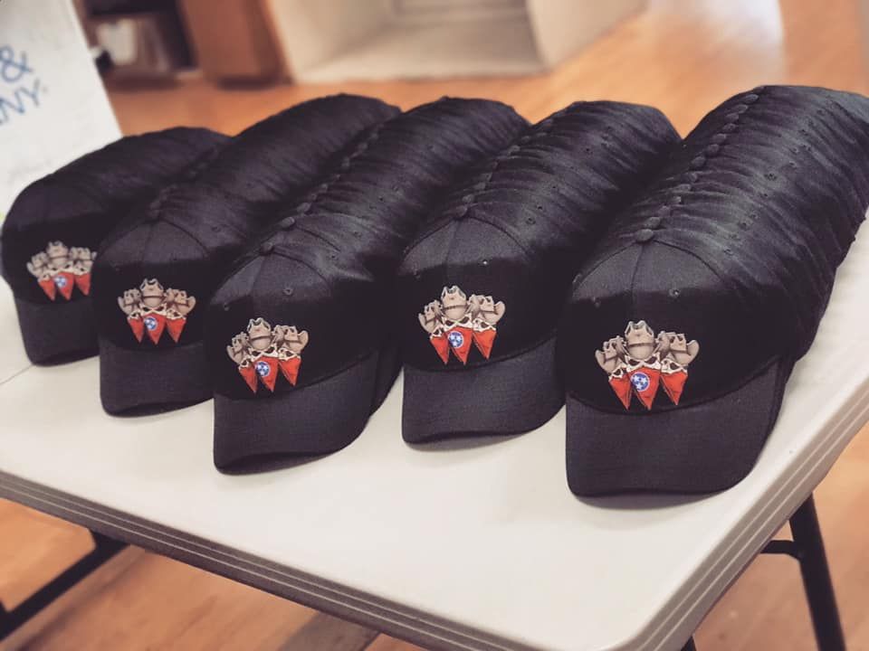 A bunch of black hats are sitting on a table