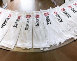 A bunch of white shirts with names on them