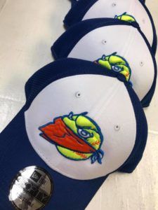 A row of blue and white hats with a tennis ball on them