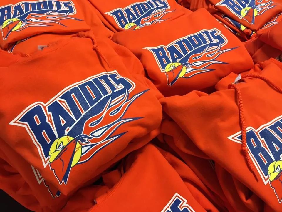 Stacks of orange Radius-logo T-shirts with blue and white lettering on display