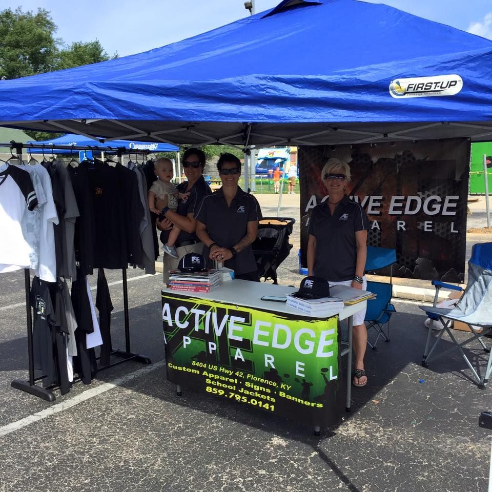 People standing around a table that says active edge apparel