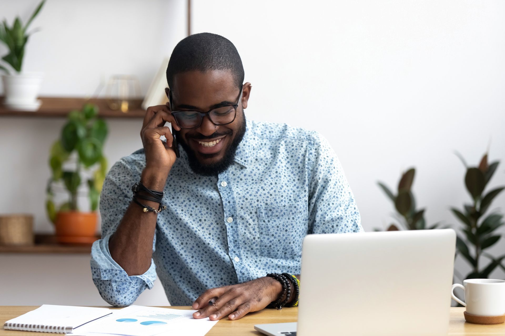 Smiling person with glasses talking on phone