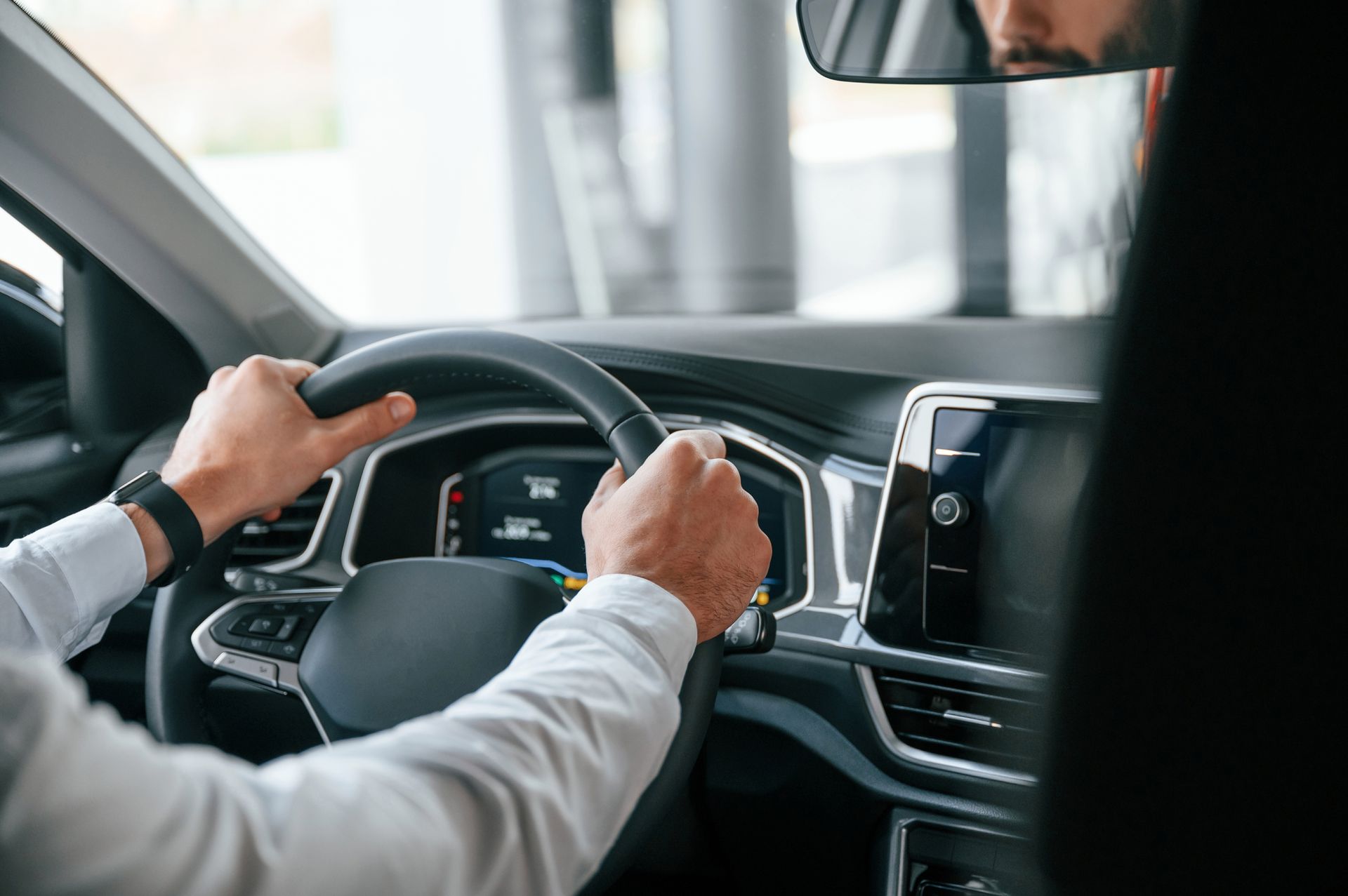 Hands gripping a car steering wheel