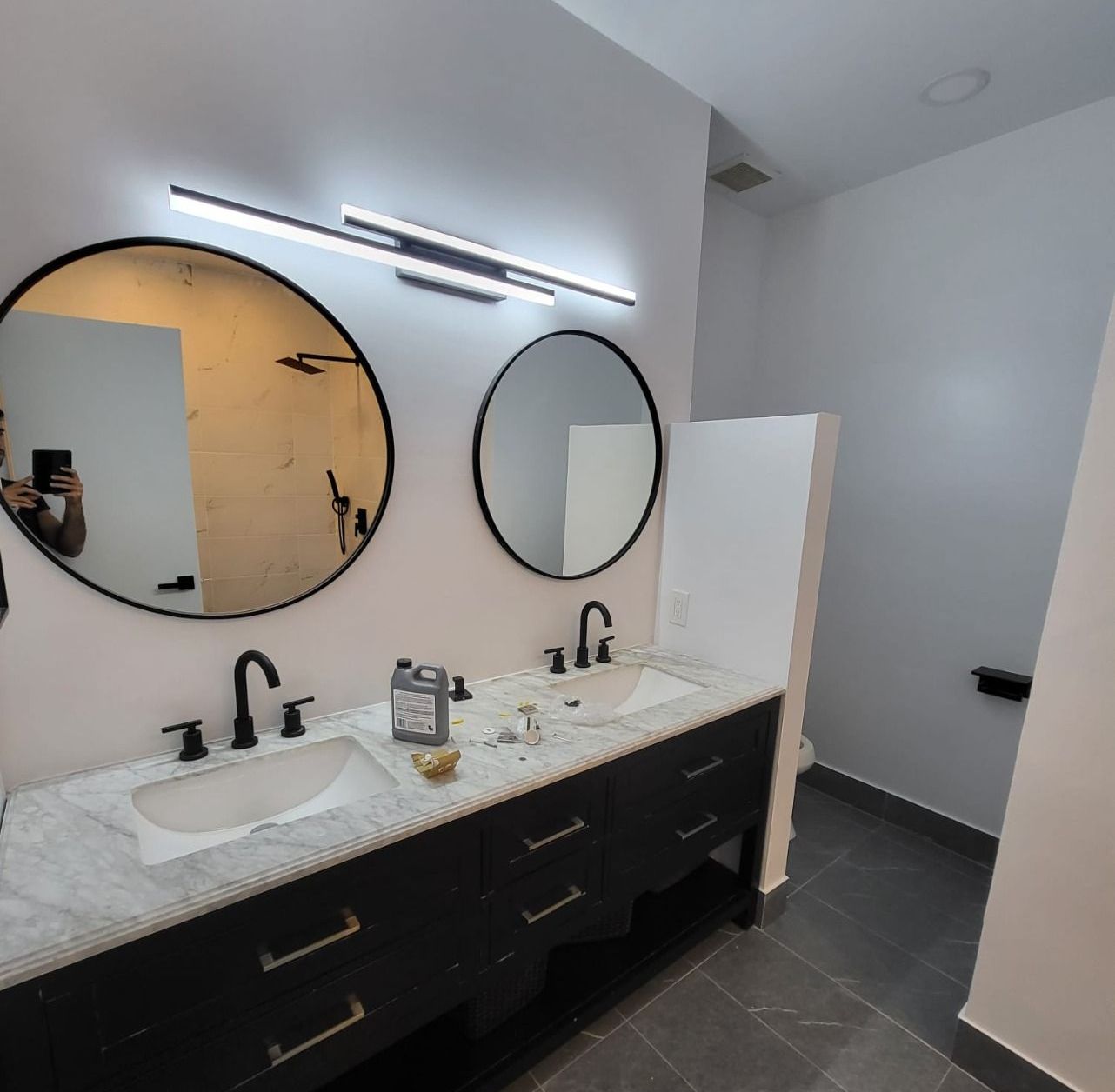 Finished product: Newly renovated bathroom with his & hers sinks and two large circular mirrors.