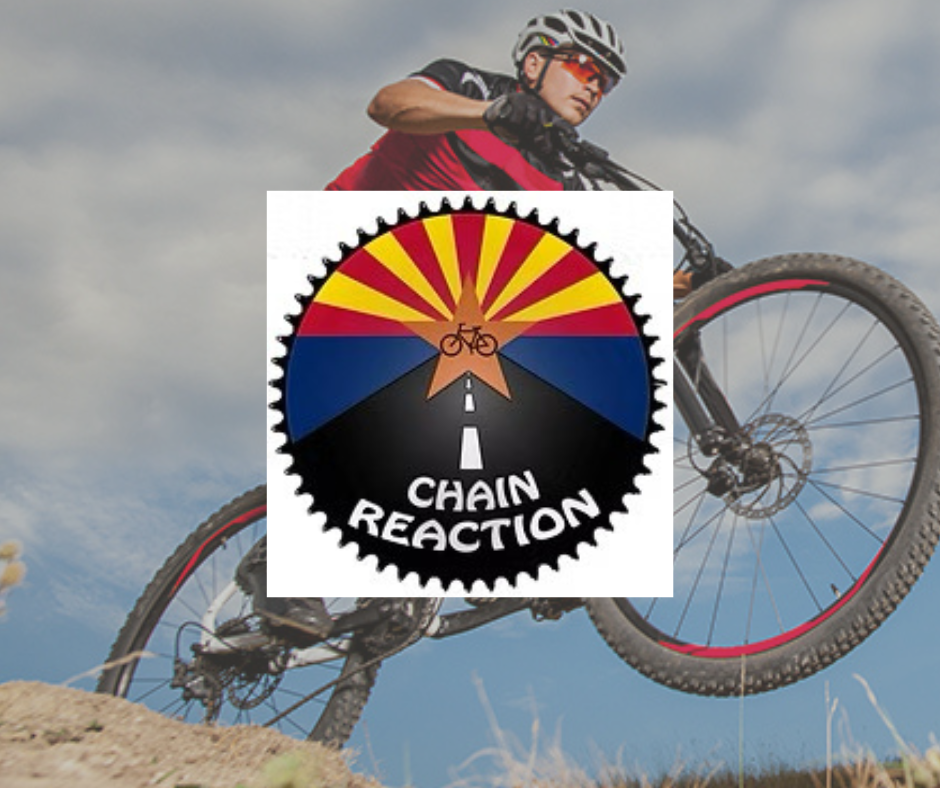 A man is riding a bike with a chain reaction logo behind him