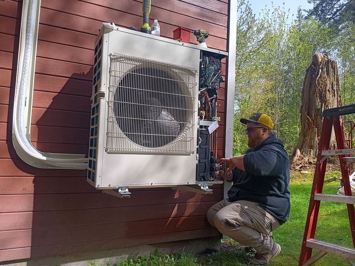 A professional technician wearing a mask is working on an air conditioner, ensuring proper maintenance and safety standards.