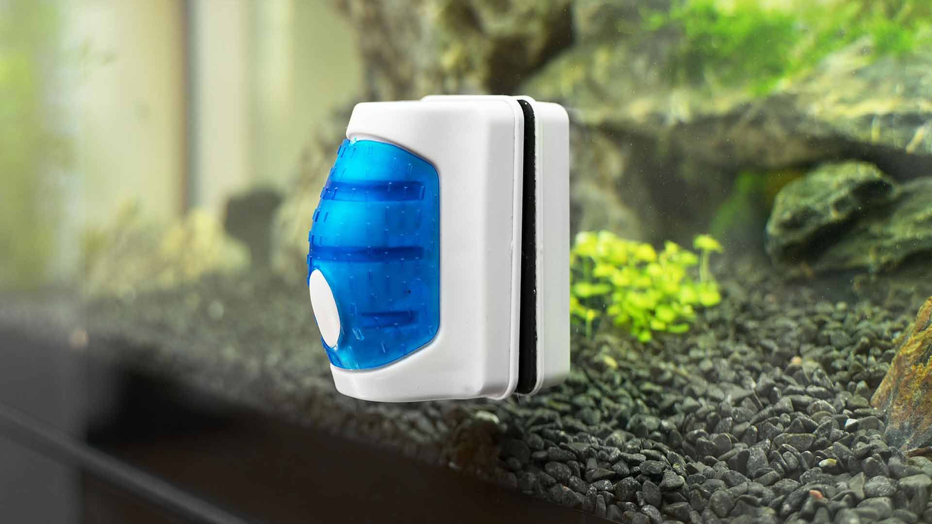 A magnetic glass cleaner is sitting on top of a fish tank.