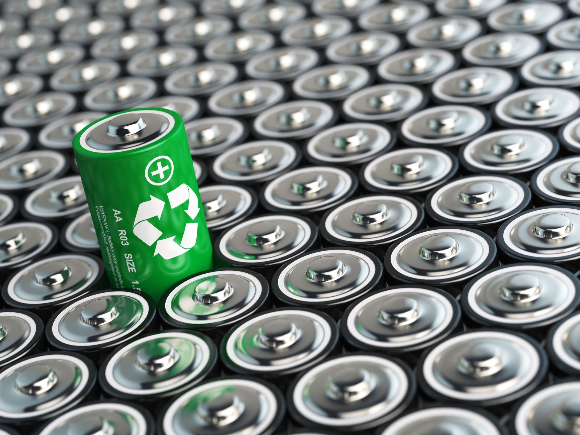 A battery recycling concept. Background from batteries and one with green recycling sign in Alameda,