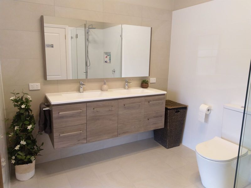 A Bathroom With Two Sinks, A Toilet And A Mirror — Custom Design Bathroom Renovations in Port Macquarie, NSW