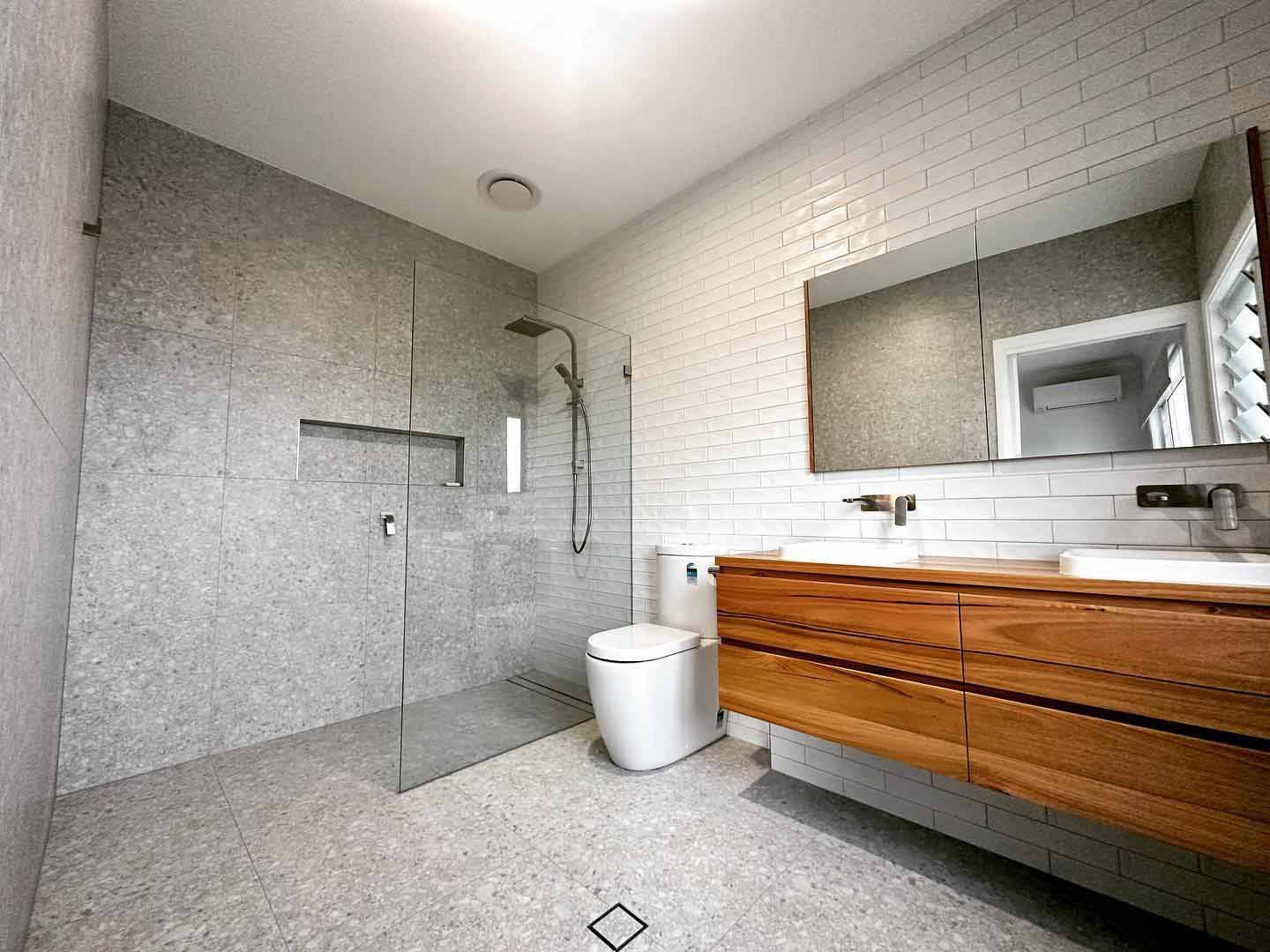A Bathroom With A Walk In Shower, Toilet, Sink And Mirror — Custom Design Bathroom Renovations in Port Macquarie, NSW