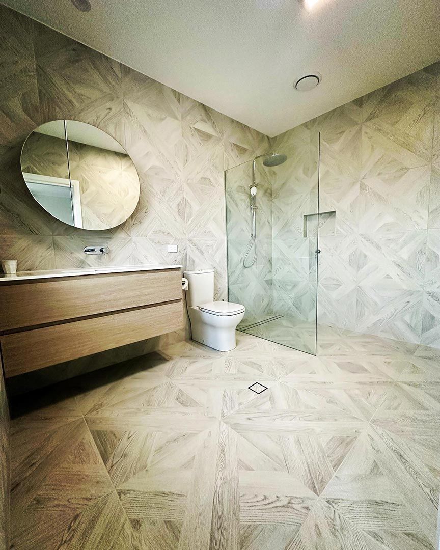 A Bathroom With A Toilet, Sink, Mirror And Walk In Shower — Custom Design Bathroom Renovations in Port Macquarie, NSW