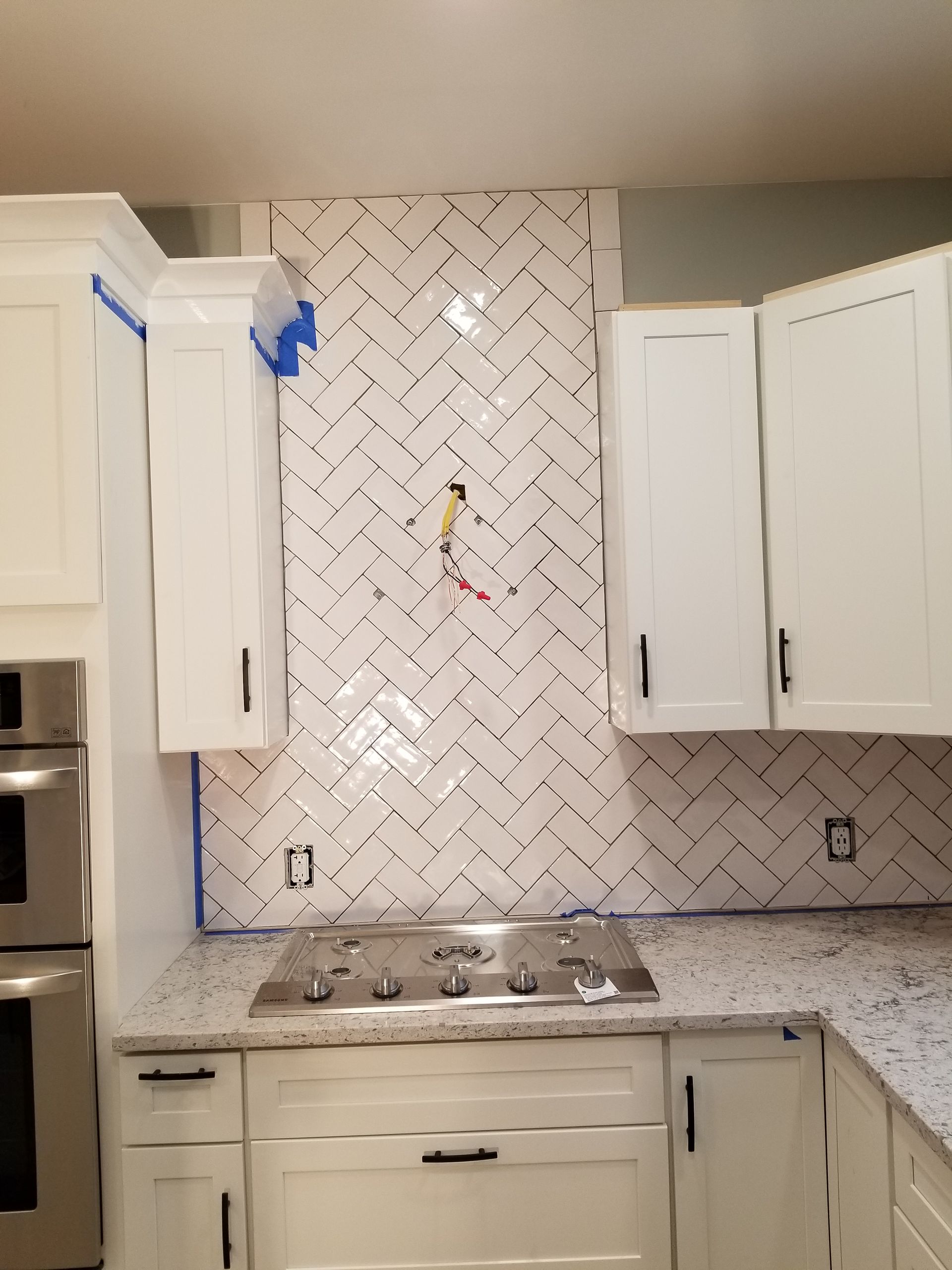 A kitchen with white cabinets and a stove top oven