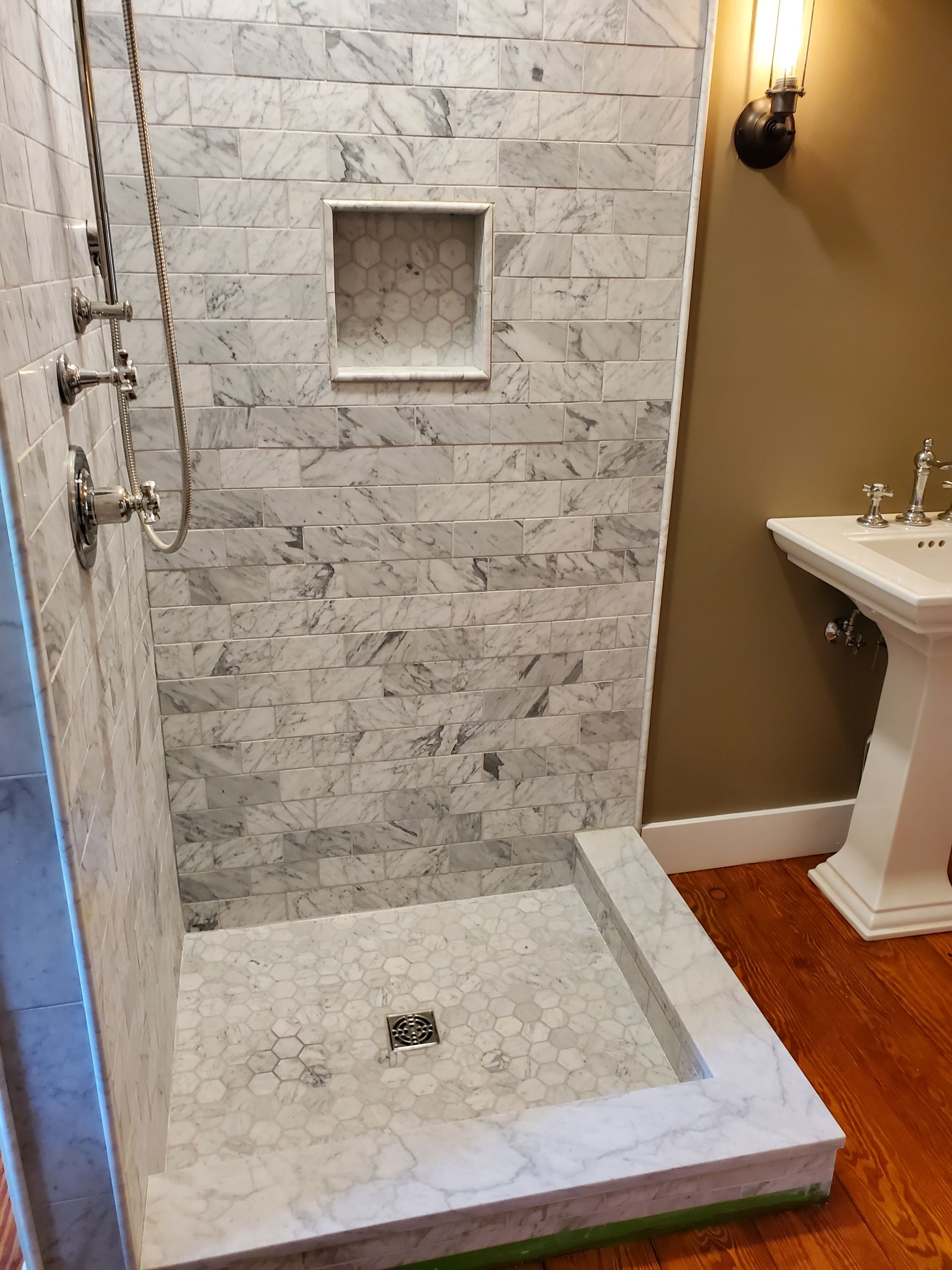 A bathroom with a walk in shower and a sink.