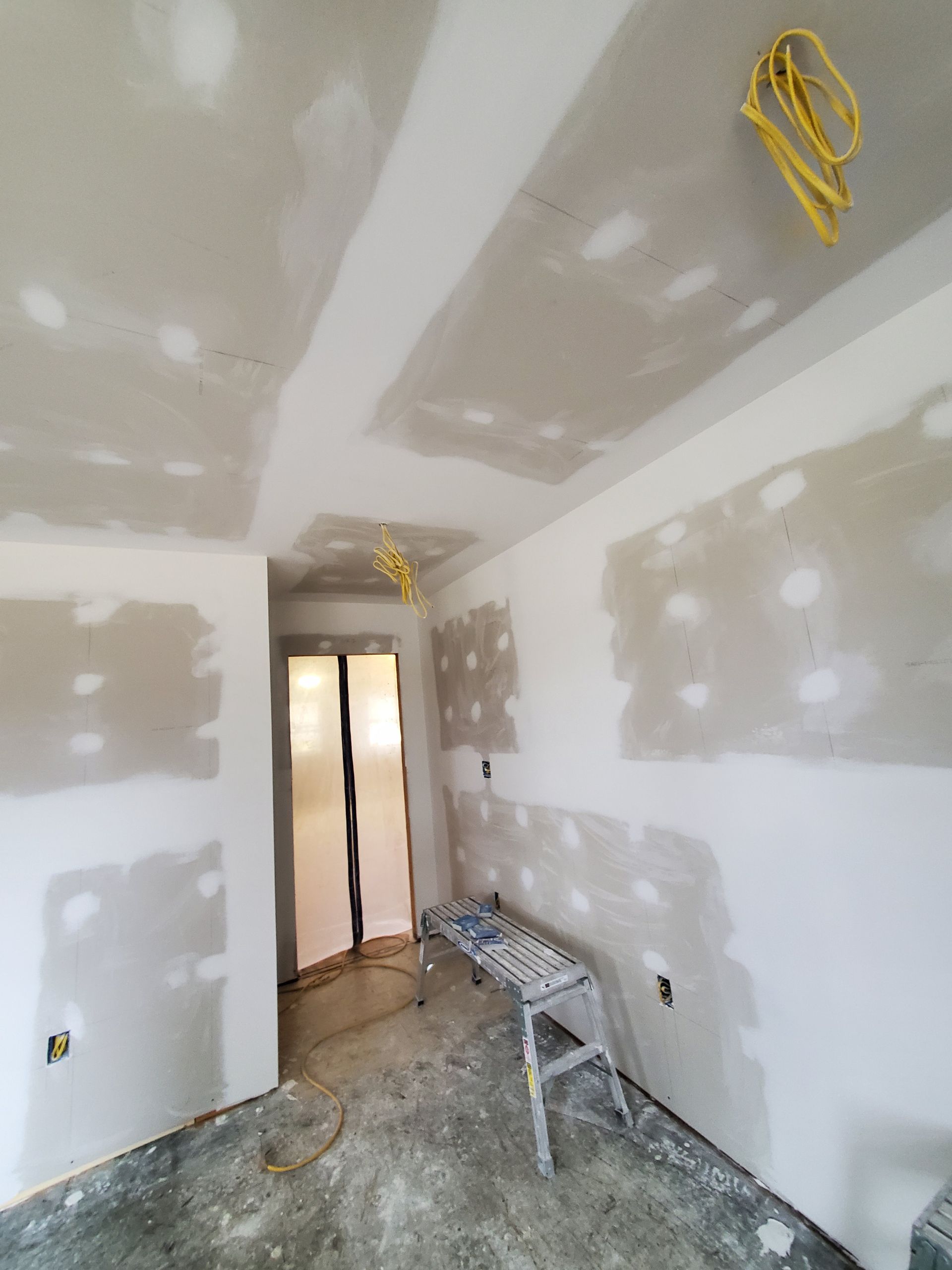 A room with a stool and a ladder in it