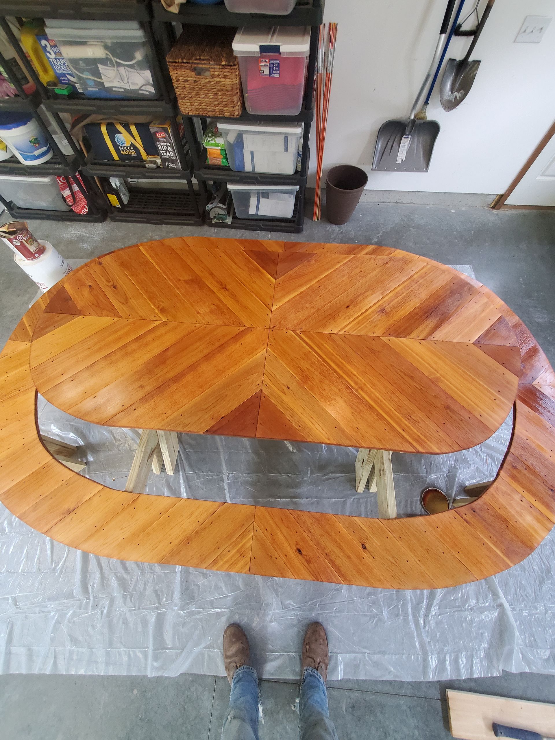 A person is standing next to a wooden table in a garage.