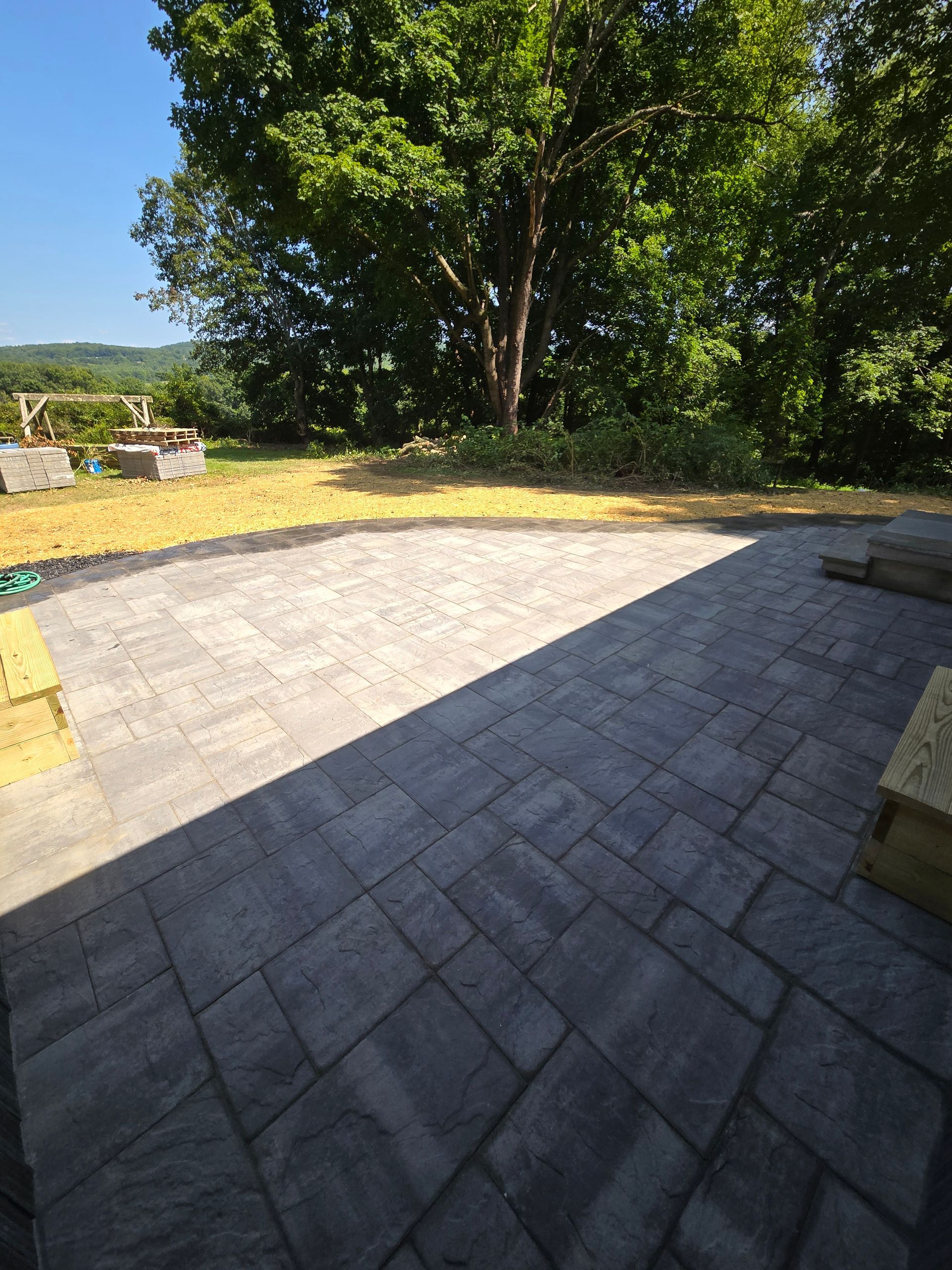 A patio with trees in the background and a blue sky