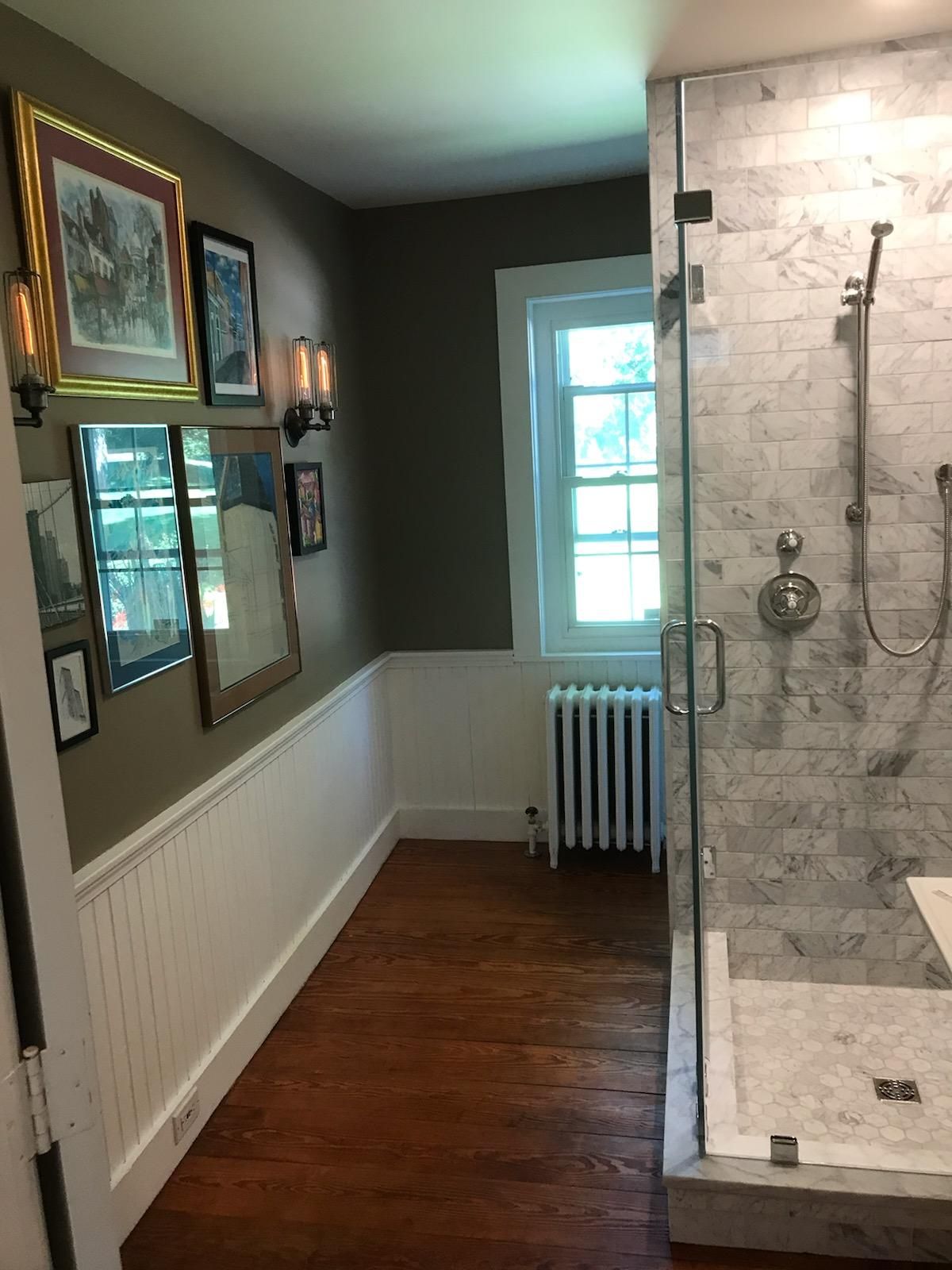 A bathroom with a walk in shower and a radiator.