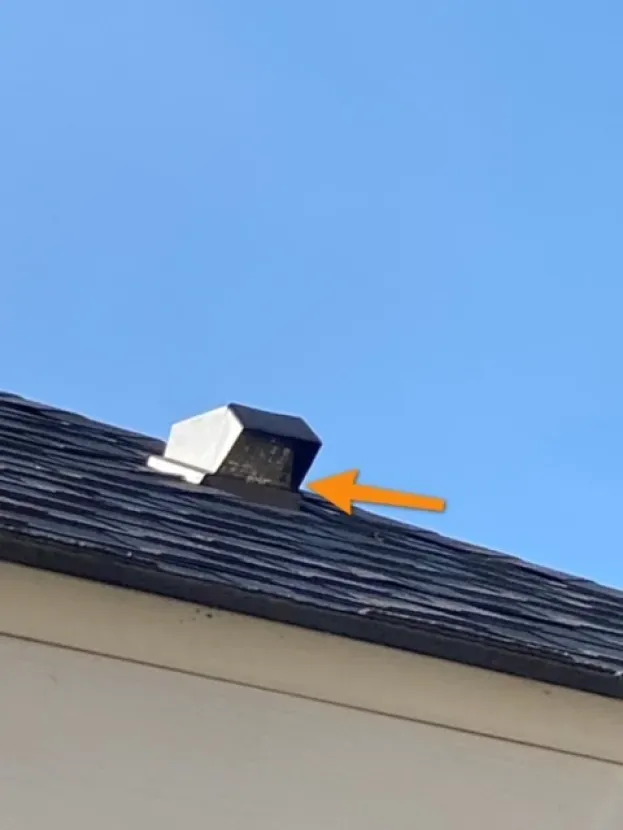 A roof with a chimney on it and an orange arrow pointing to it.