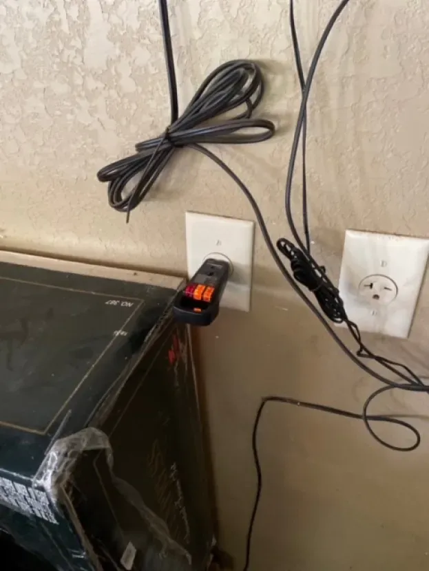 A remote control is plugged into a wall outlet.