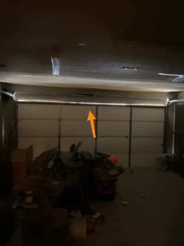 A dark garage with a yellow arrow pointing up.