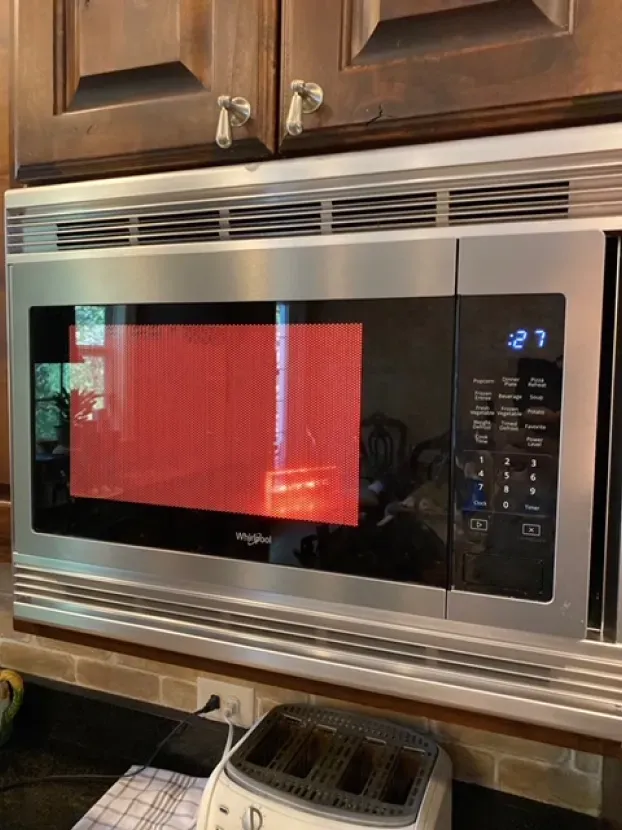 A microwave oven is sitting on top of a kitchen counter next to a toaster oven.