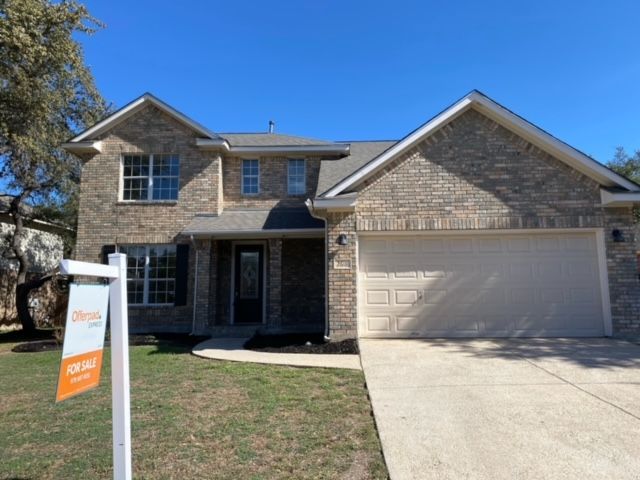 A house with a for sale sign in front of it