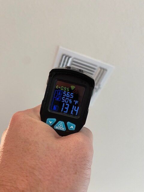 A person is holding a digital thermometer in their hand.
