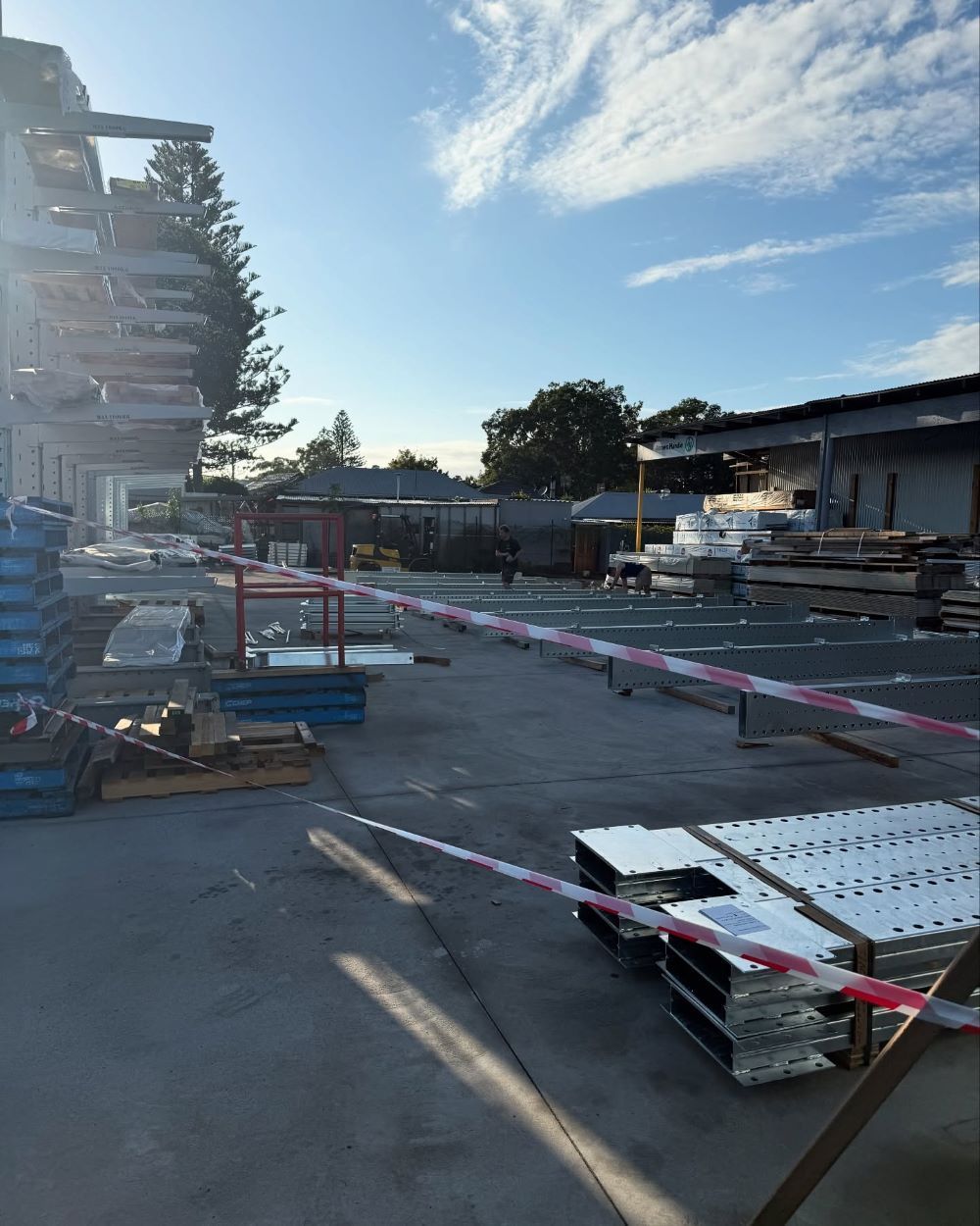 An Industrial Yard with Construction Materials, Caution Tape — Express Timber Solutions In Long Jetty, NSW