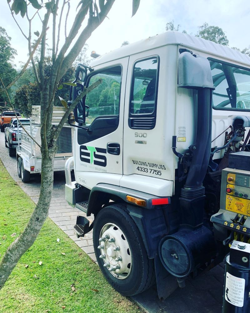 White Truck with Black Exhaust Pipe, Green and Black Logo — Express Timber Solutions In Long Jetty, NSW