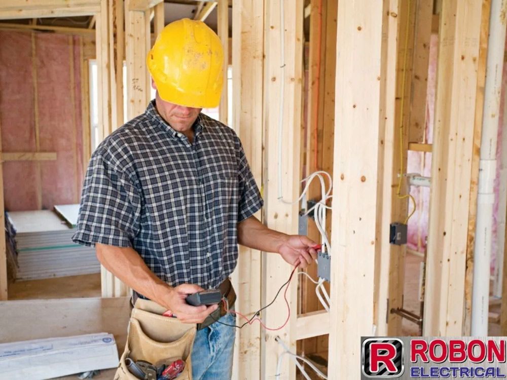 Electrician Testing Wiring Inside A Timber-framed Home Under Construction