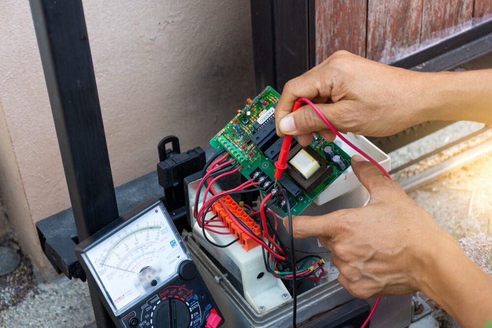 A Person Is Using A Multimeter To Test A Circuit Board  — Robon Electrical In Cairns, QLD