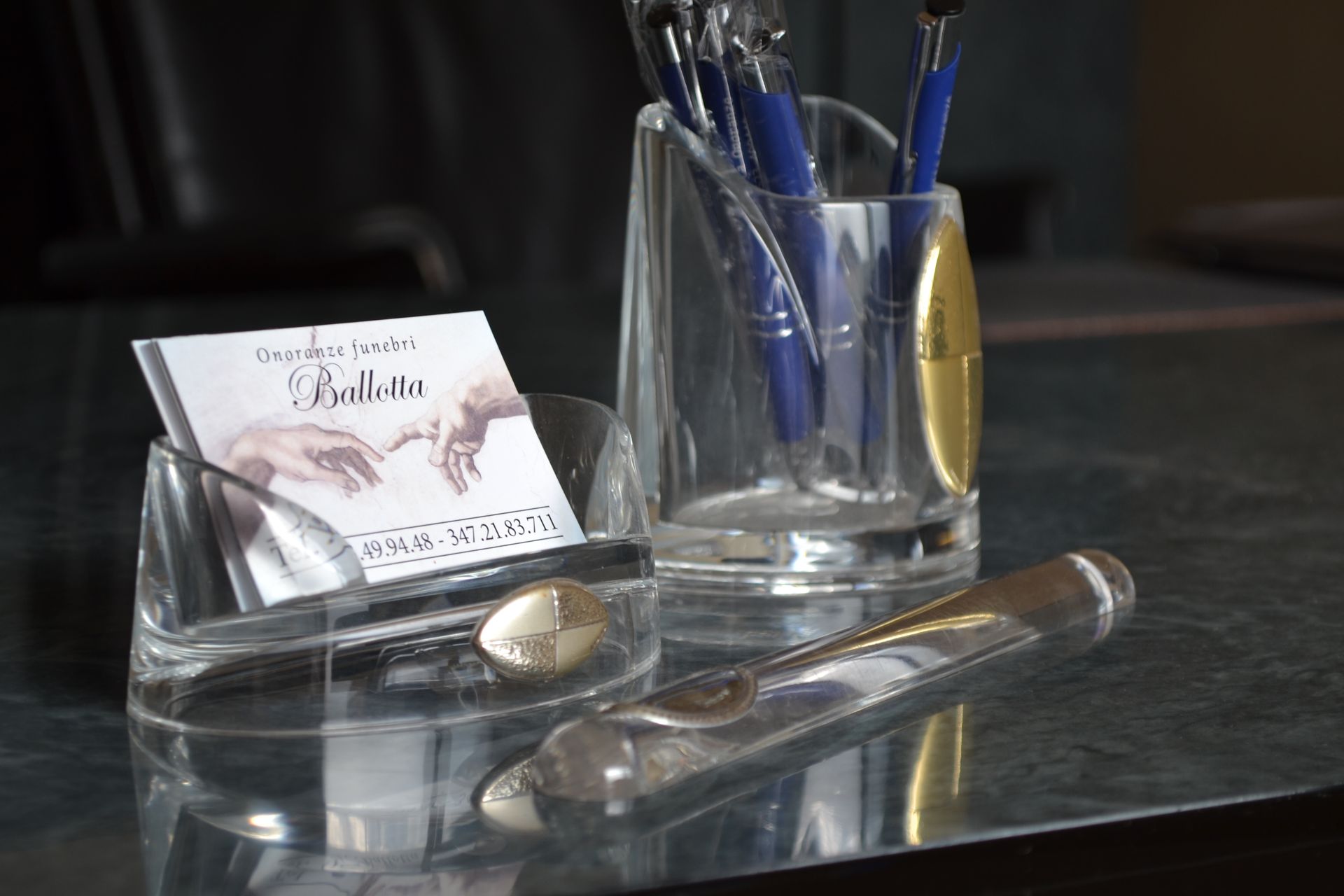 Un porta biglietti da visita con l'immagine della creazione di Adamo e il brand onoranze funebri Ballotta