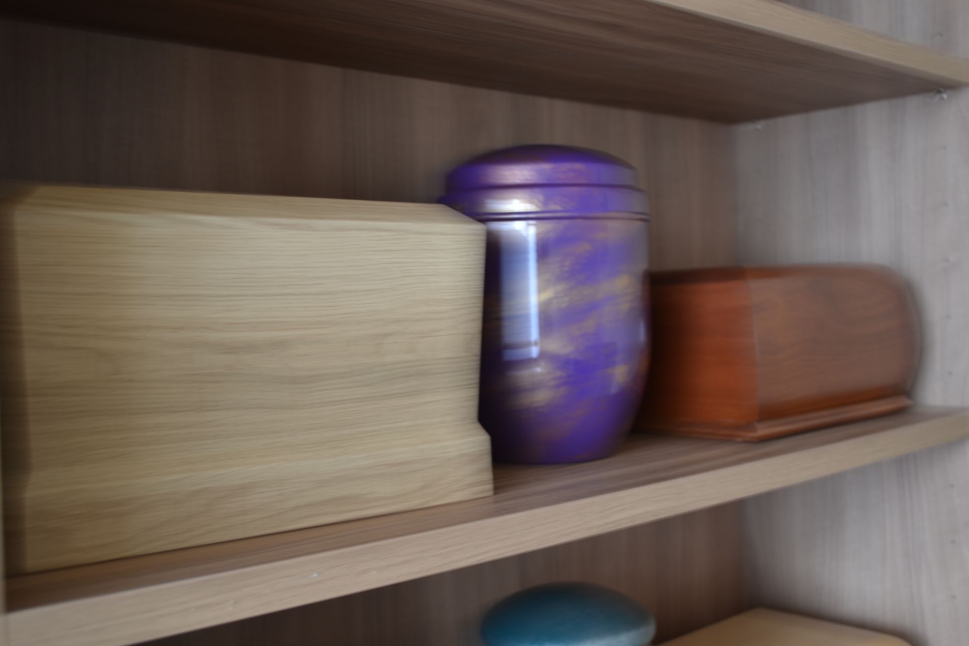 urna viola appoggiata su mensole di legno
