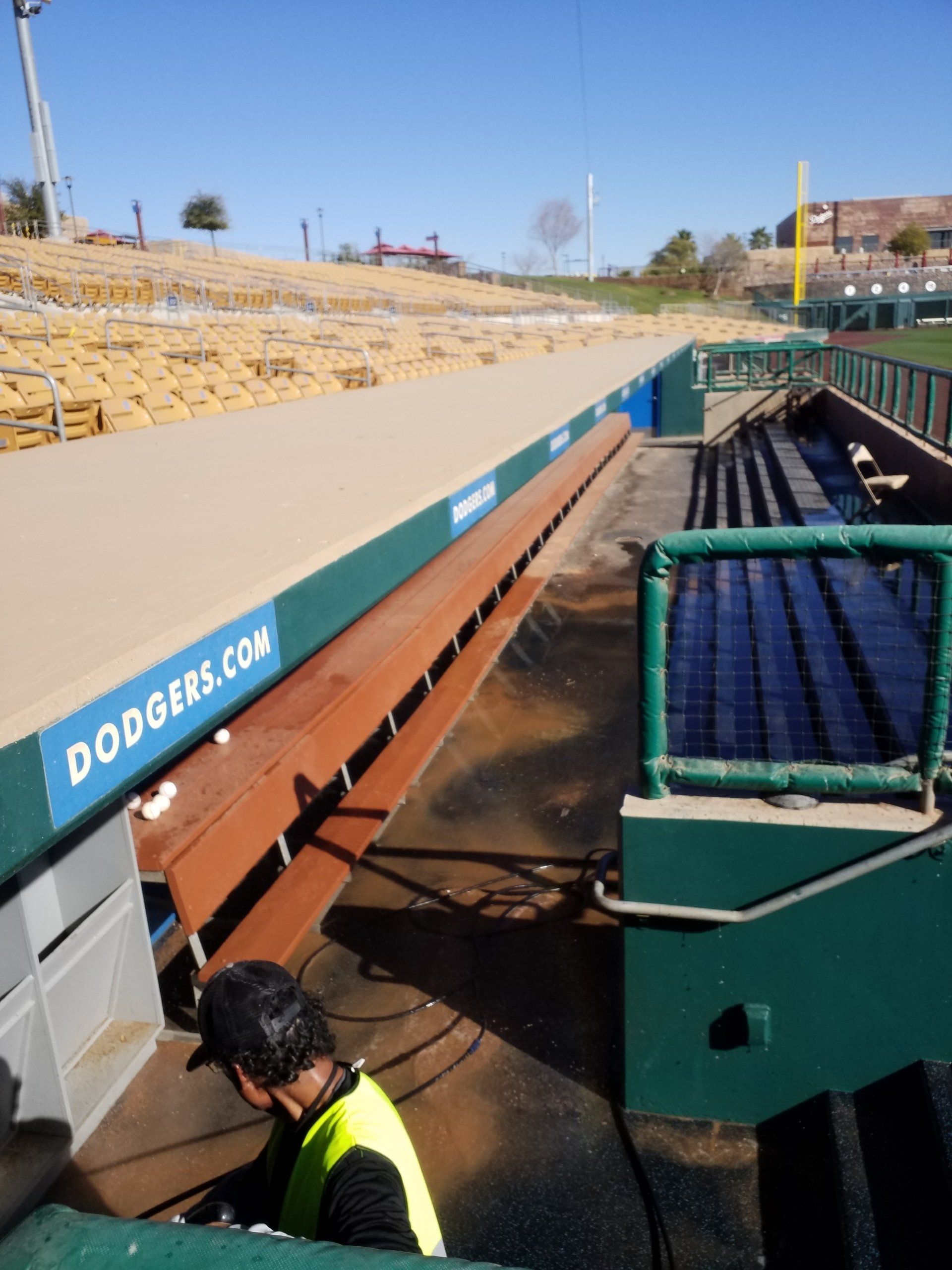 A man in a yellow vest is working on a dodgers stadium