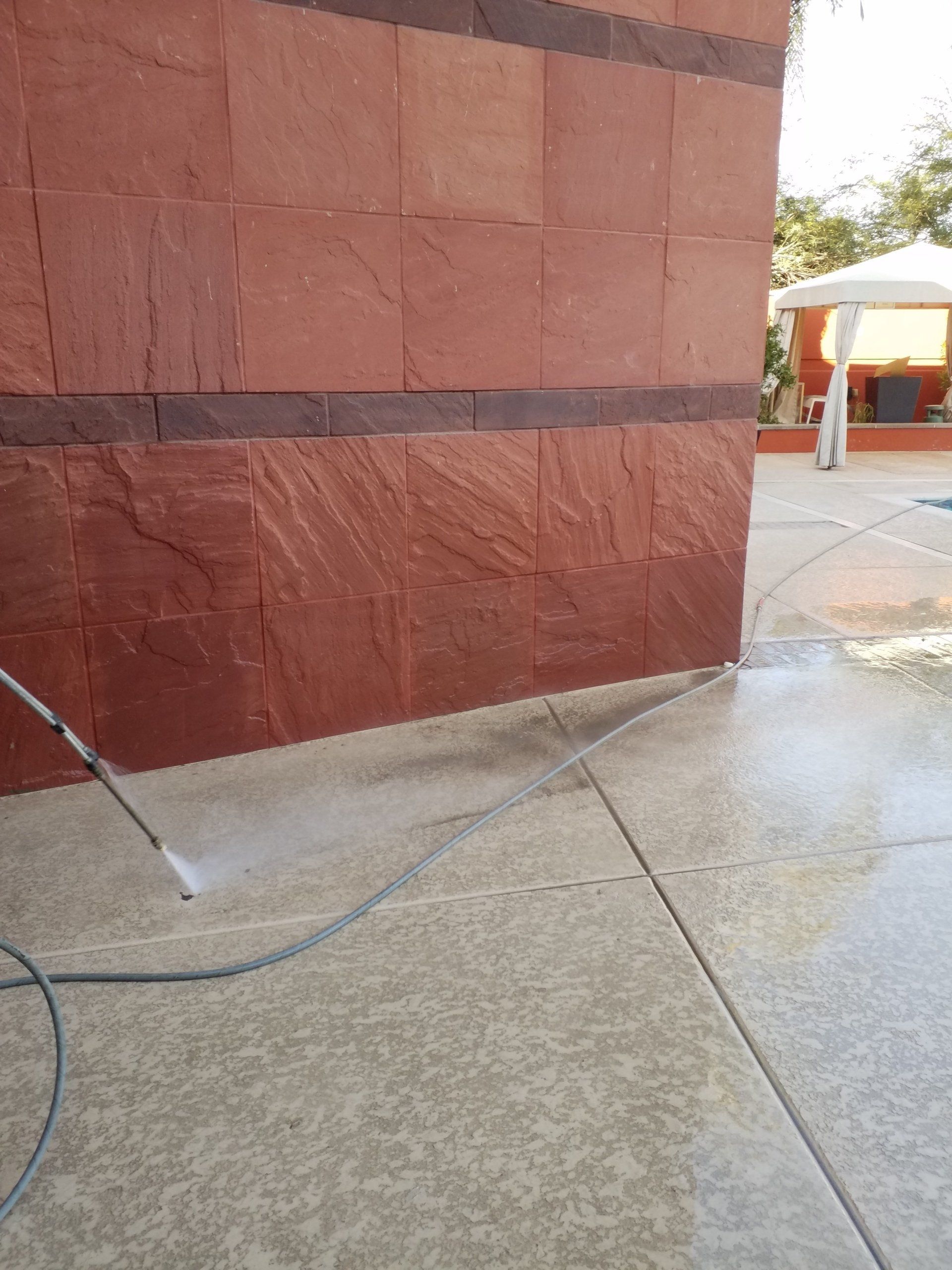 A person is using a pressure washer to clean a concrete floor.