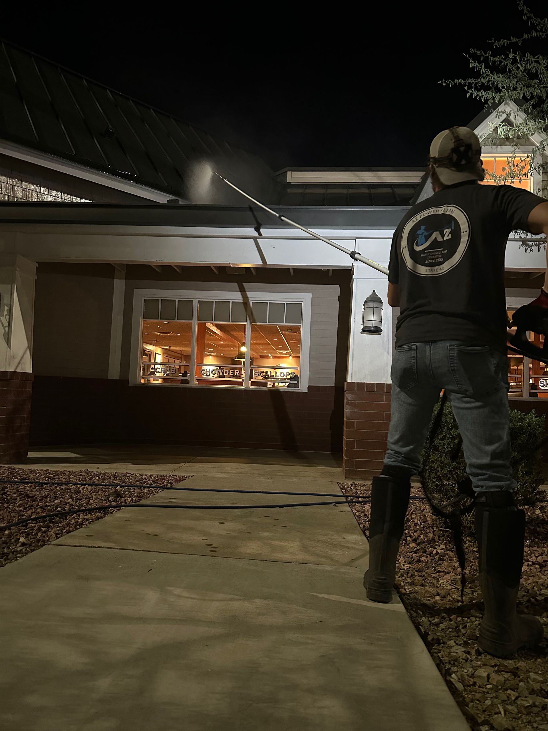 A man is standing in front of a house at night.