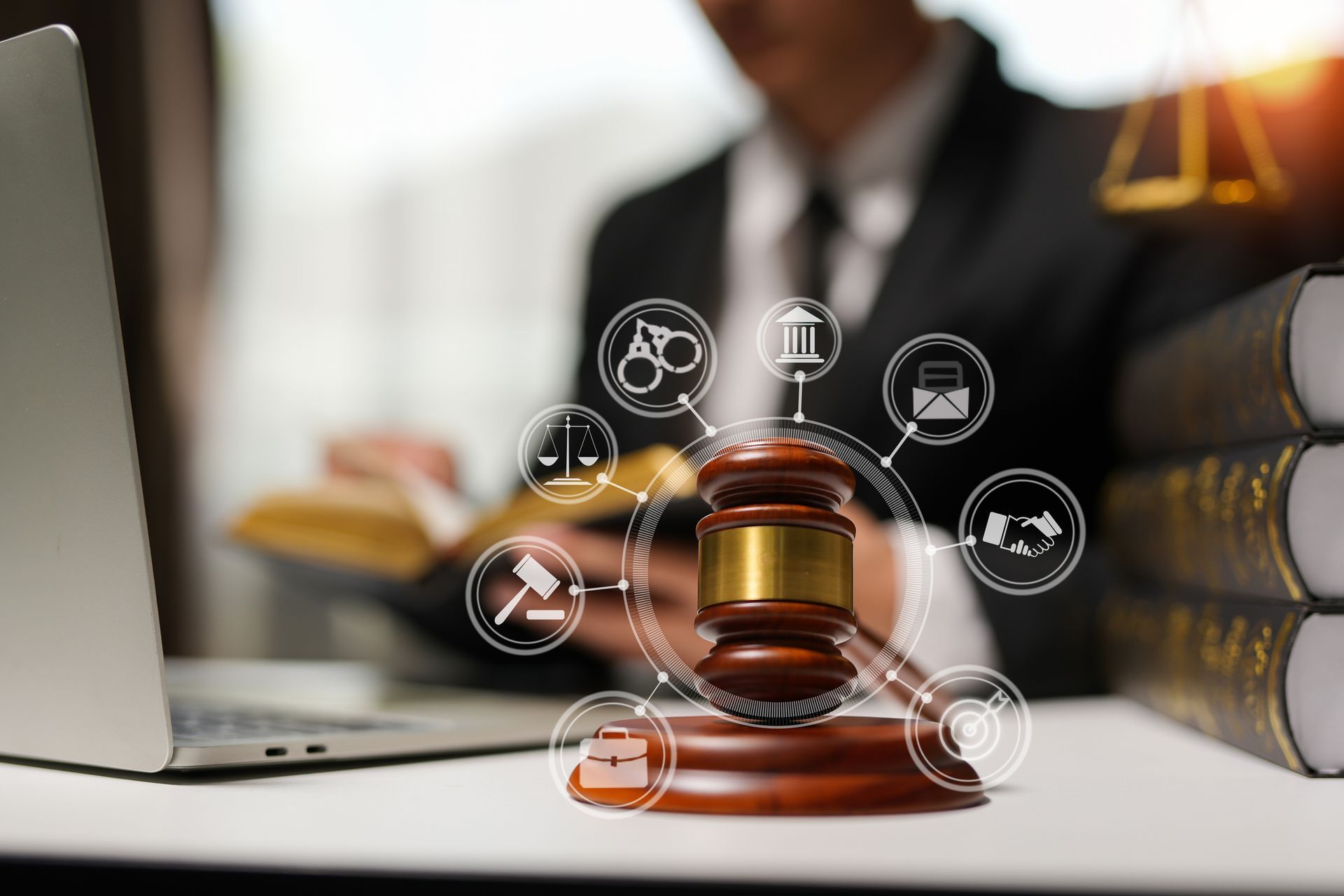 Gavel with lawyer in background, surrounded by law icons. Laptop, books, and scales of justice visible.