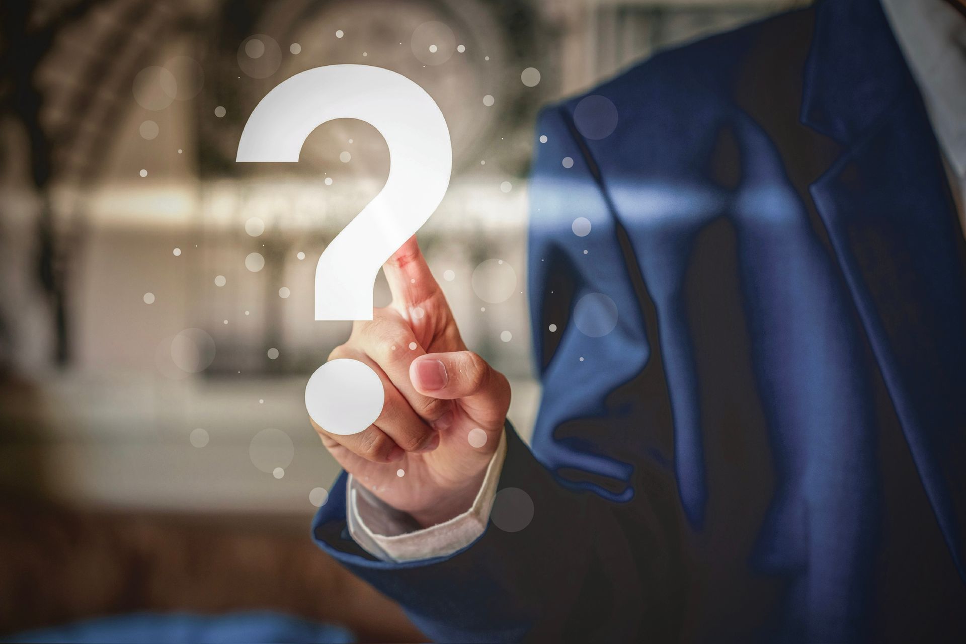 A person in a suit touches a large, glowing white question mark.