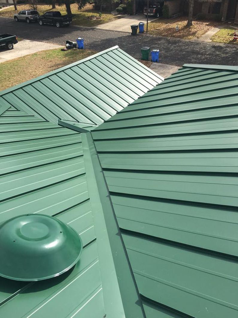 Green metal roof with a vent, photographed from above.