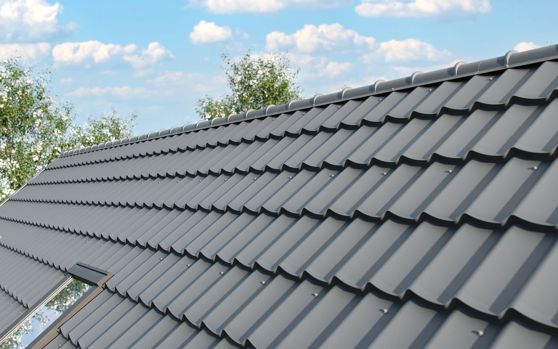 Gray tiled roof with sky and trees in the background.