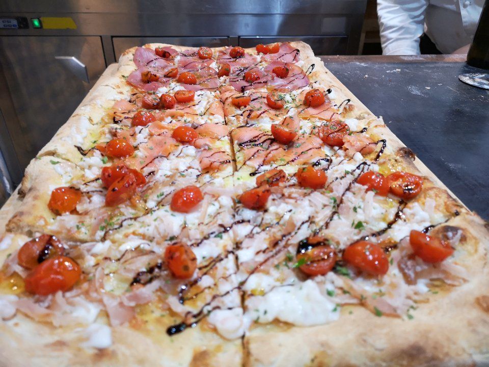 pizza al metro con salmone e tonno affumicati, pomodorini e glassa