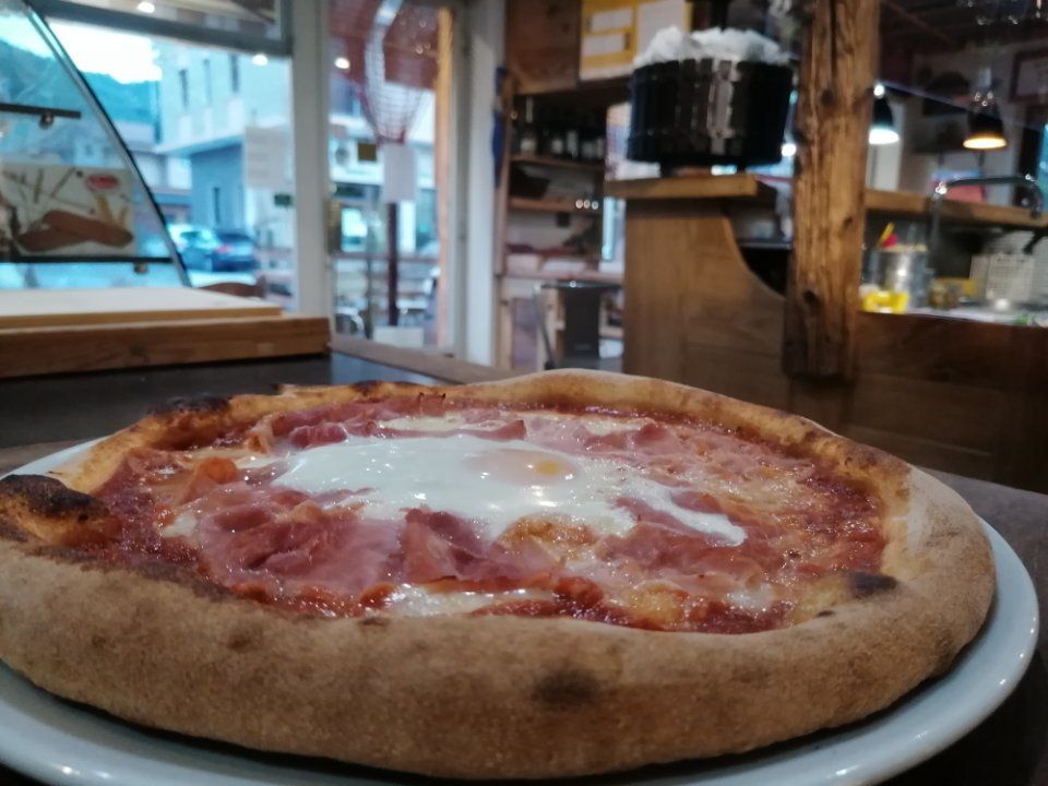 pizza tonda con prosciutto e uovo