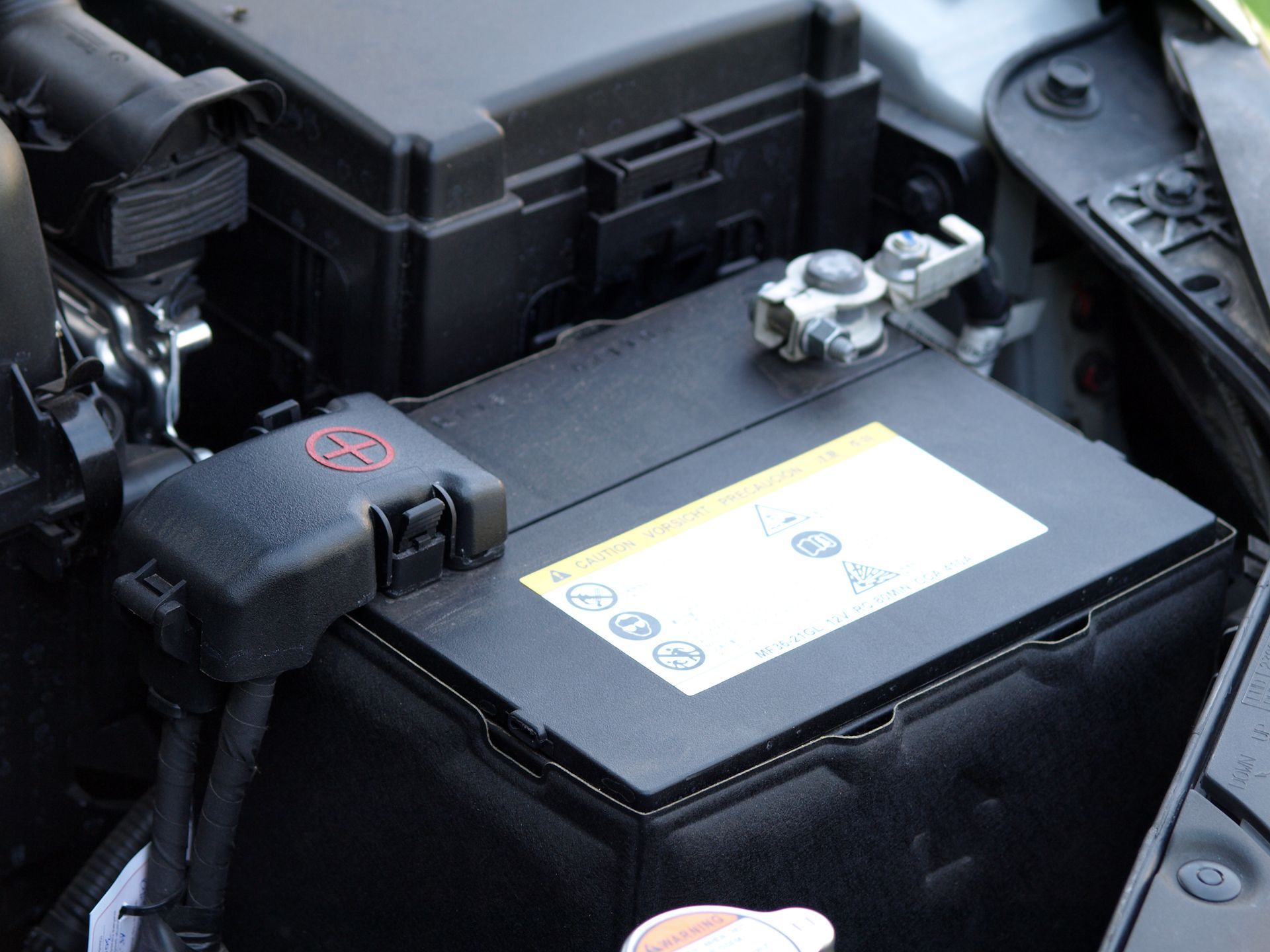 Powerful car battery secured under the hood, ensuring smooth starts every time.