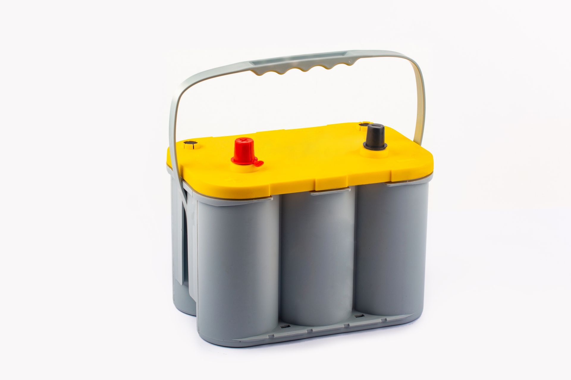 Spiral cell Optima battery with yellow top and gray body on white background.